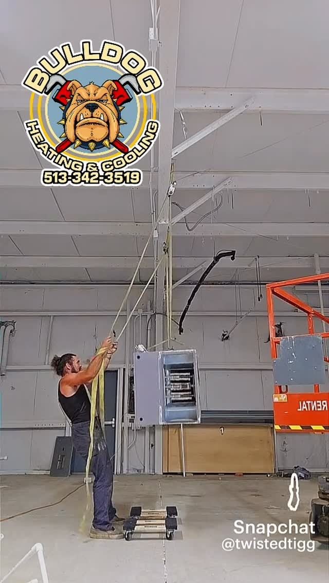 Technician on a ladder in a commercial shop space
